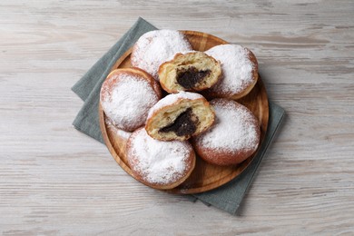 Photo of Delicious sweet buns with poppy seeds on light wooden table, top view