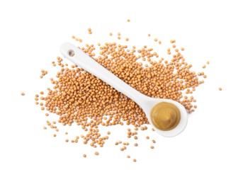 Photo of Fresh tasty mustard sauce in spoon and dry seeds isolated on white, top view