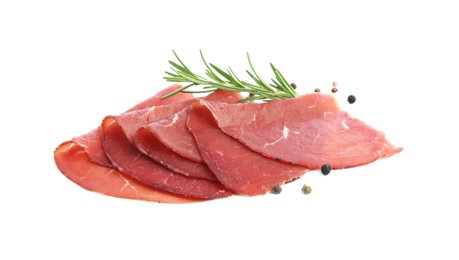 Photo of Slices of tasty bresaola, peppercorns and rosemary isolated on white