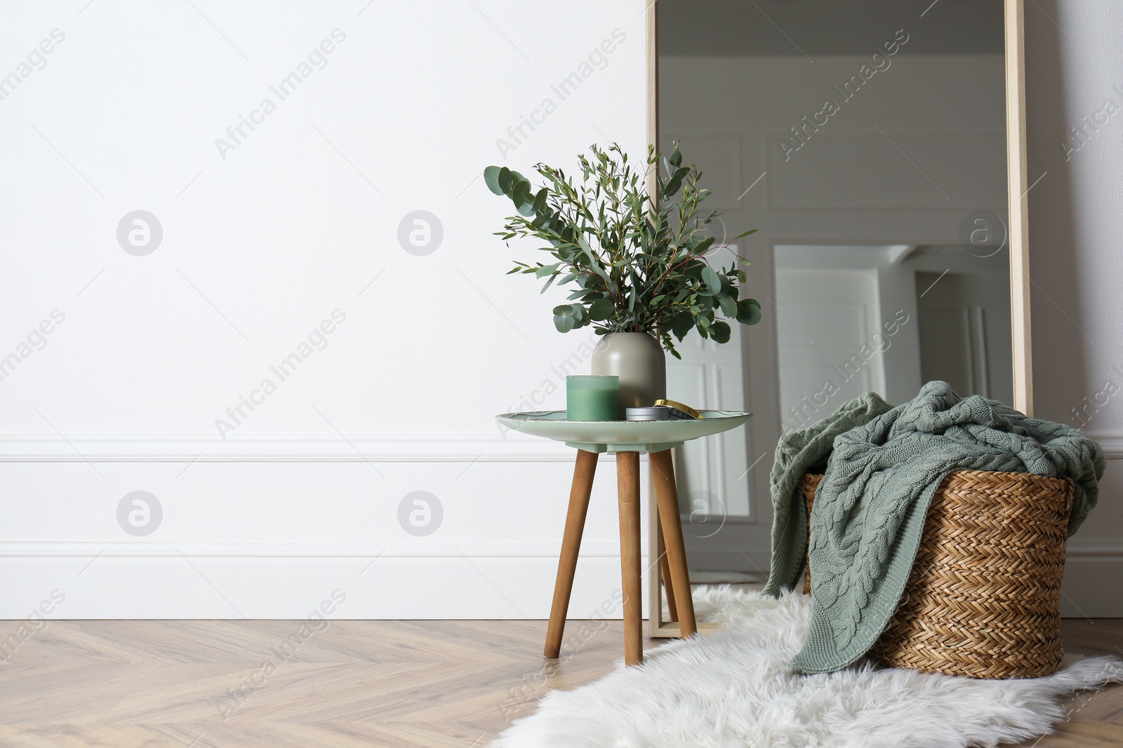 Photo of Beautiful living room interior with eucalyptus branches. Space for text