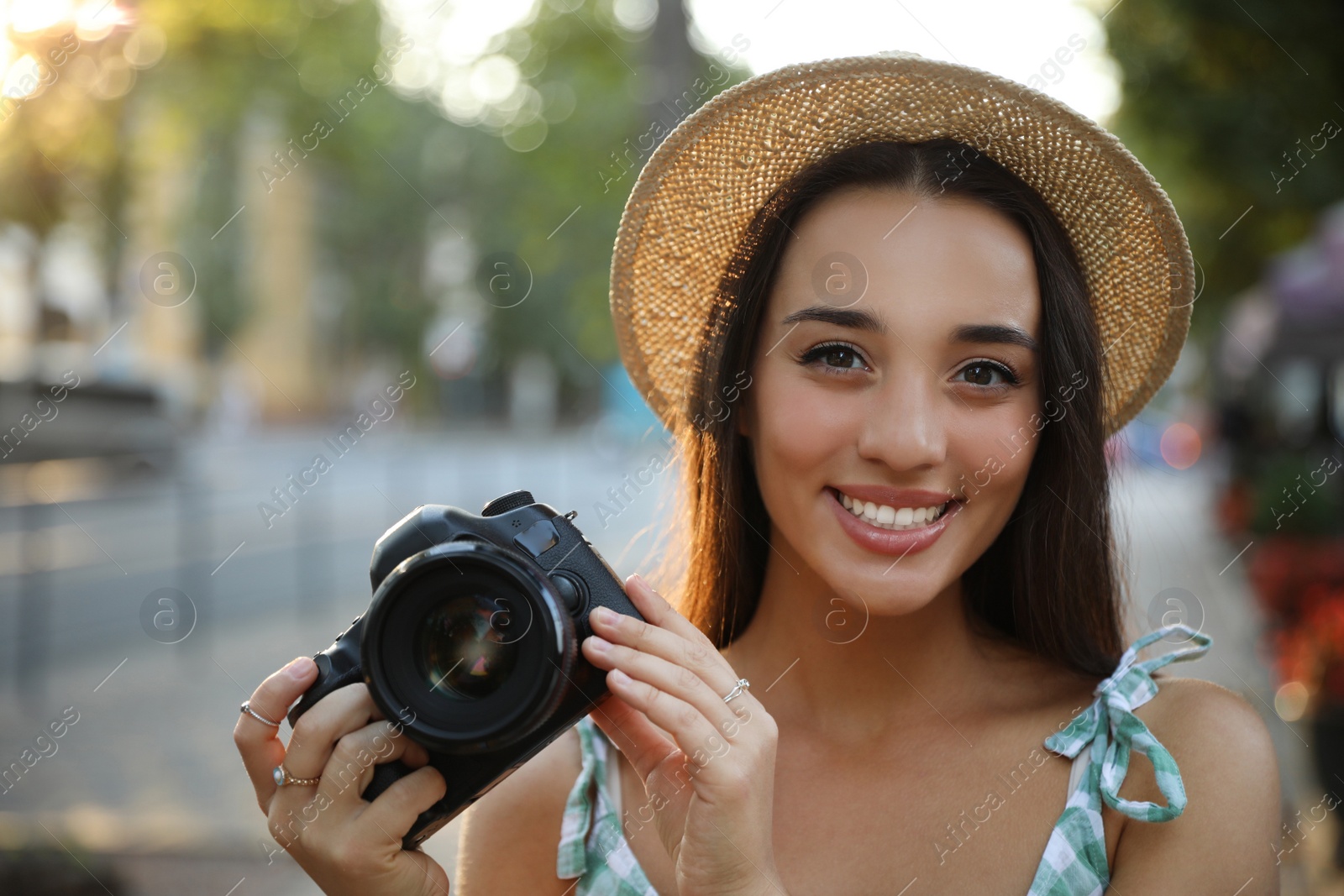 Photo of Young photographer with professional camera on city street