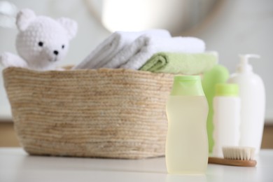 Photo of Baby cosmetic products, toy and towels on white table, space for text