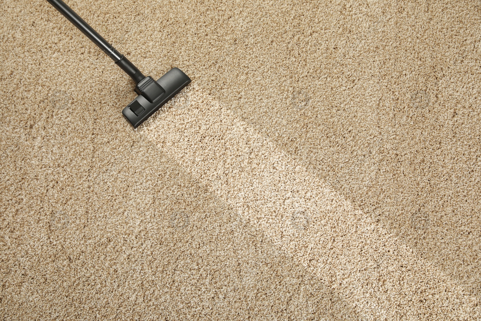 Image of Hoovering carpet with vacuum cleaner, above view and space for text. Clean trace on dirty surface