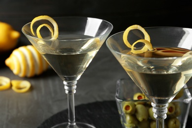 Glasses of Lemon Drop Martini cocktail with zest on grey table, closeup