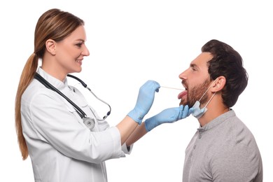Smiling doctor examining man`s oral cavity with tongue depressor on white background
