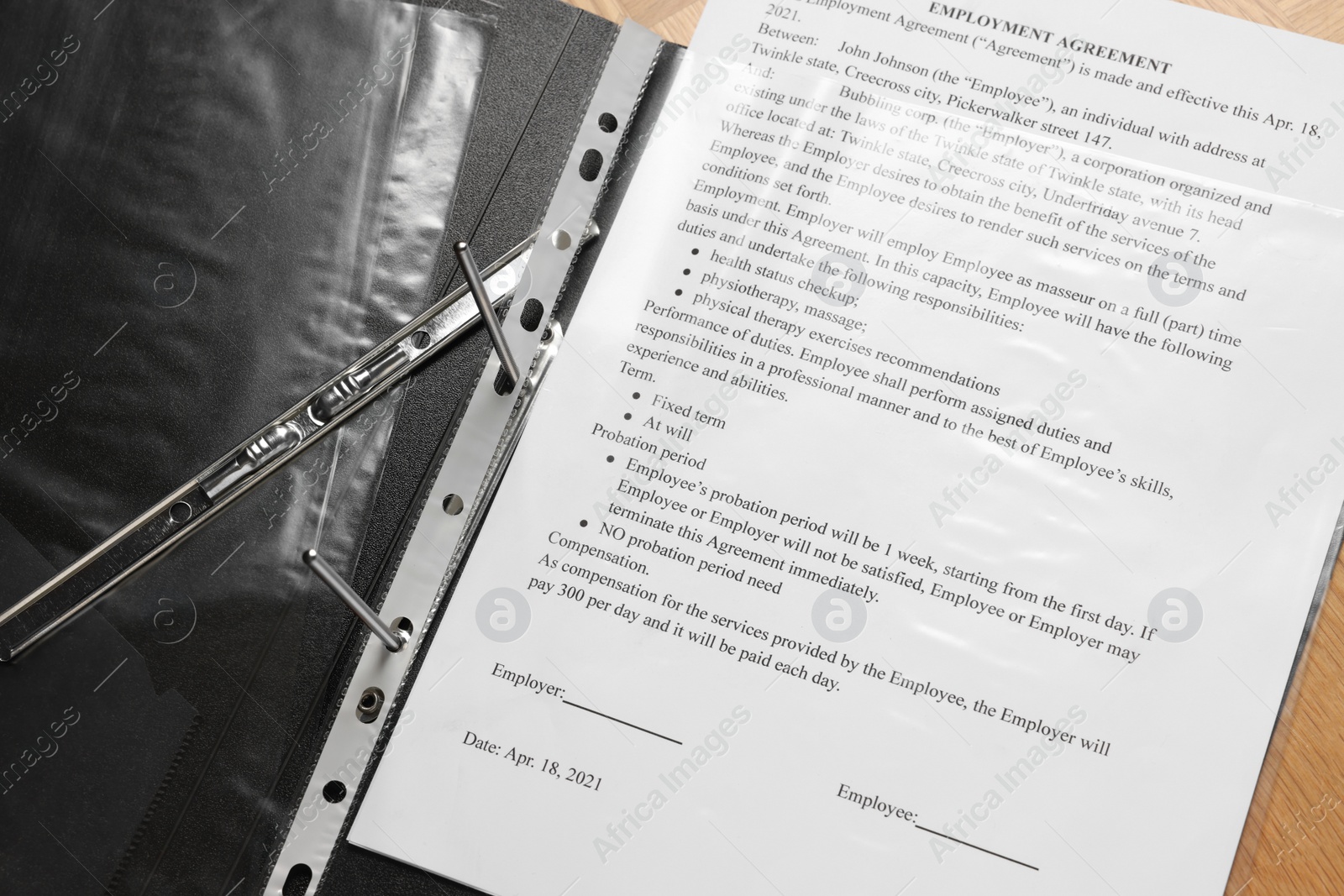 Photo of File folder with punched pocket and document on wooden table, closeup