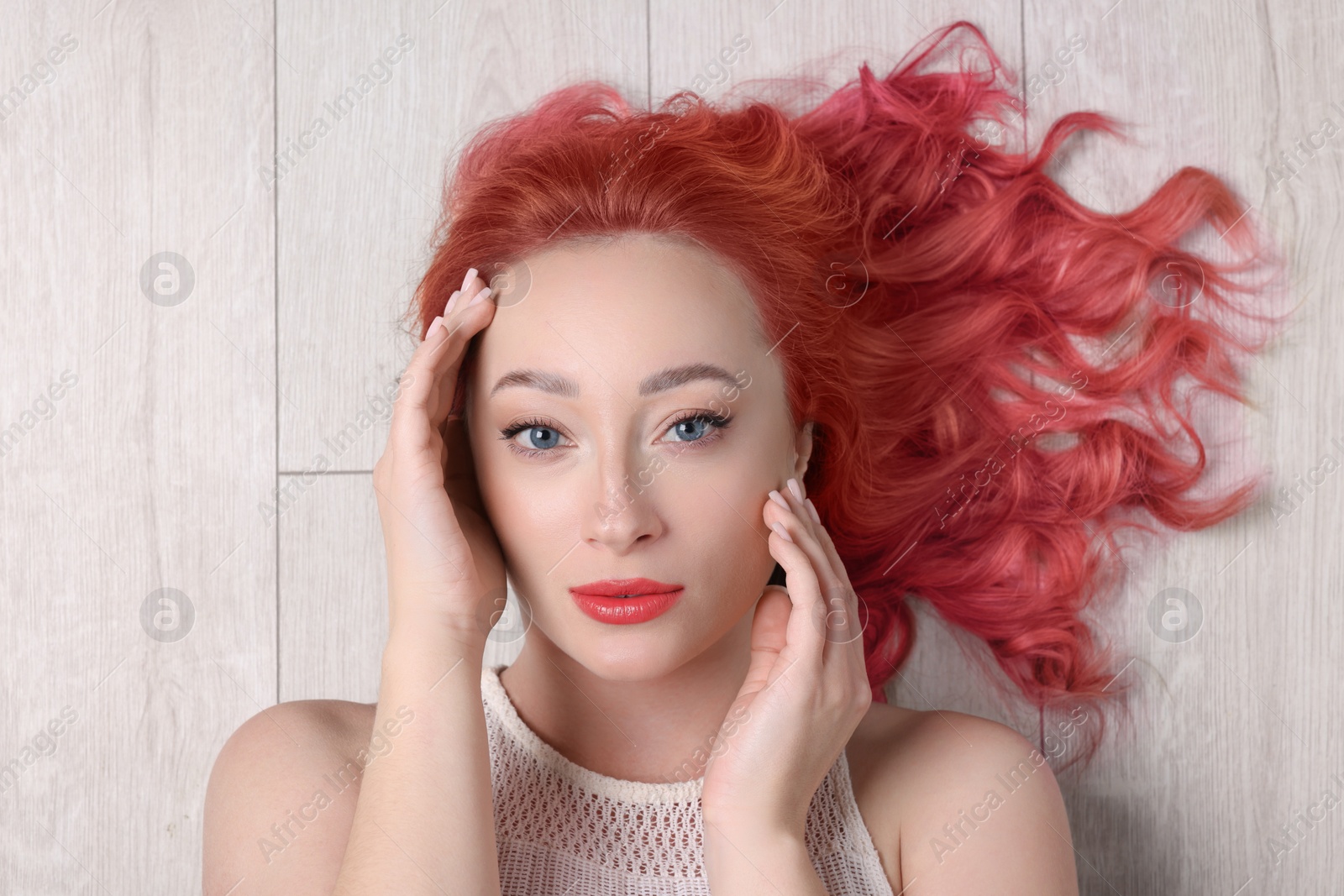 Image of Trendy hairstyle. Young woman with colorful dyed hair on white wooden background, top view