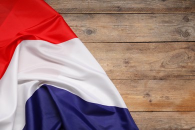 Photo of Flag of Netherlands on wooden background, top view. Space for text