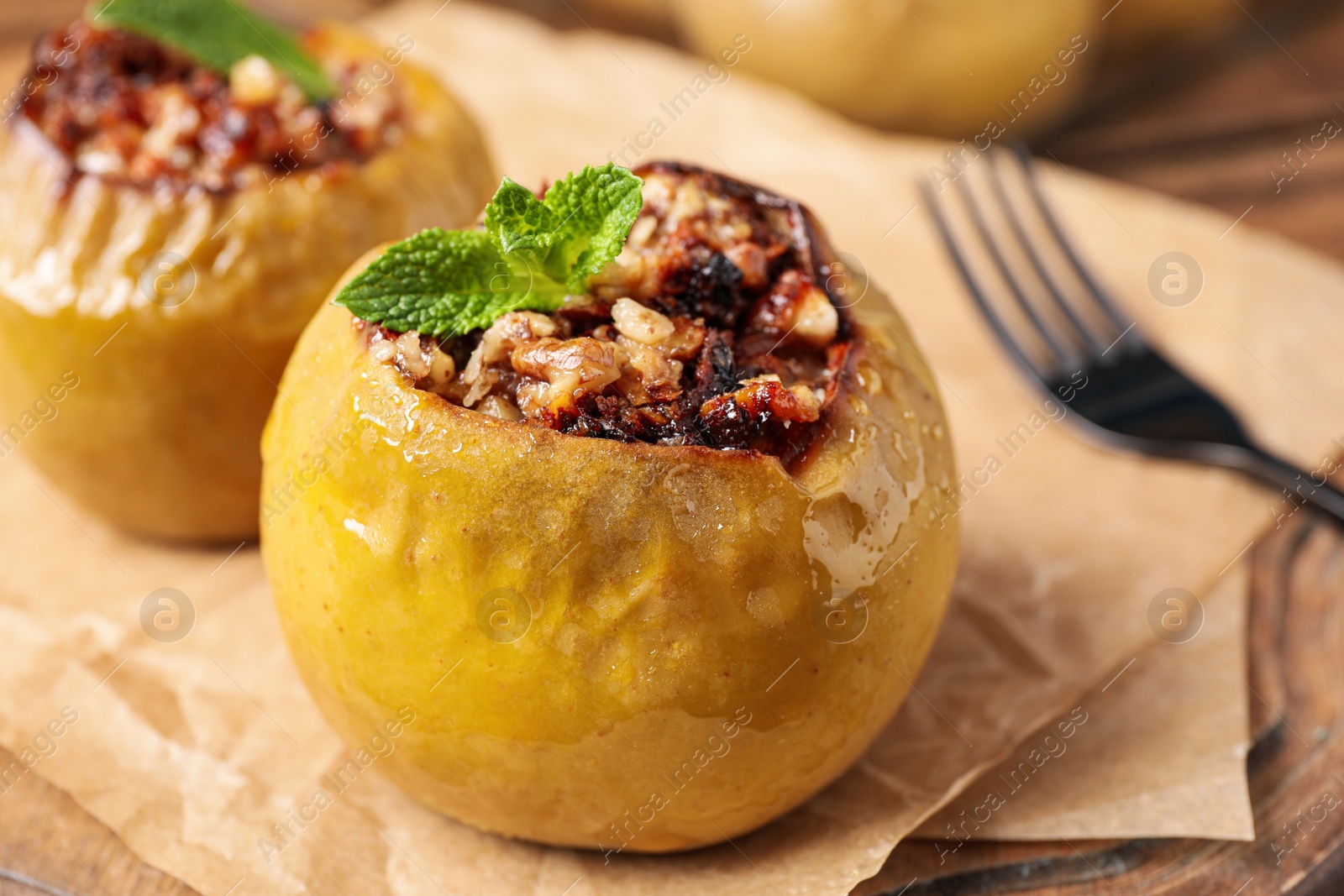 Photo of Baked apple with mint on parchment, closeup