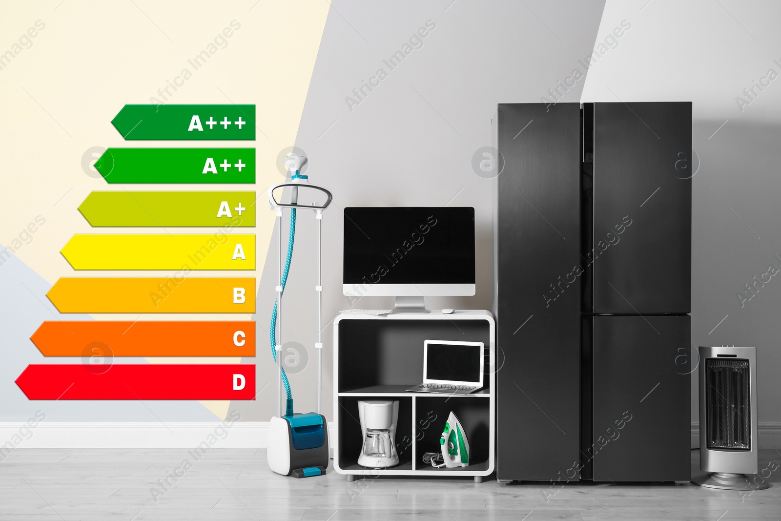 Image of Energy efficiency rating label and different household appliances near color wall indoors