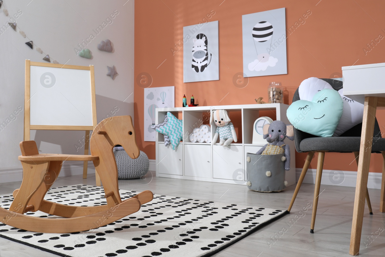 Photo of Wooden rocking horse and cute toys in playroom. Interior design