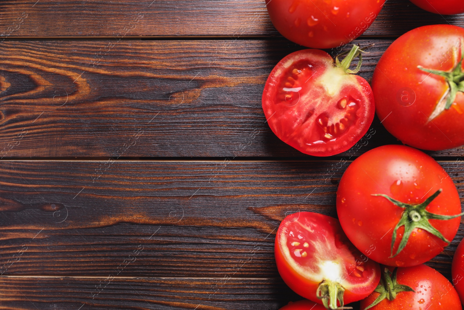 Photo of Fresh ripe tomatoes on wooden table, flat lay. Space for text