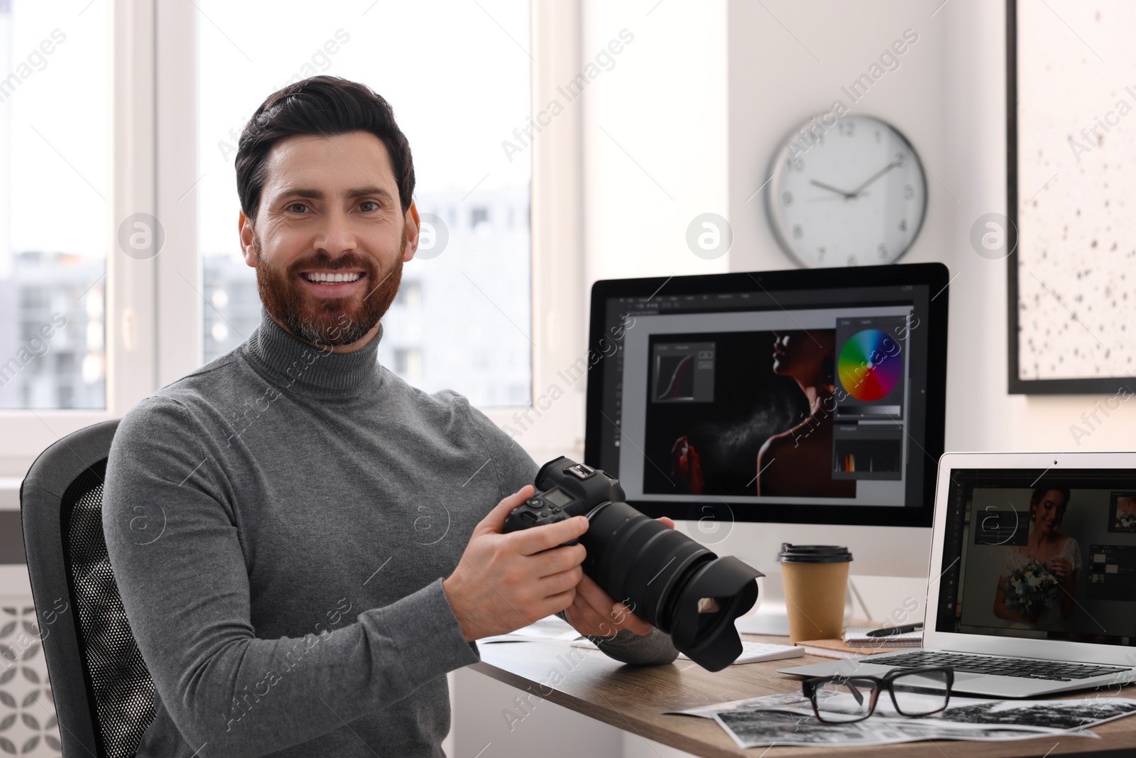 Photo of Professional photographer with digital camera at table in office