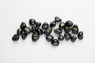 Photo of Black rune stones on white background, top view