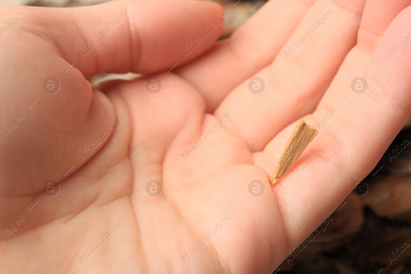 Photo of Woman with splinter in her finger on blurred background, closeup