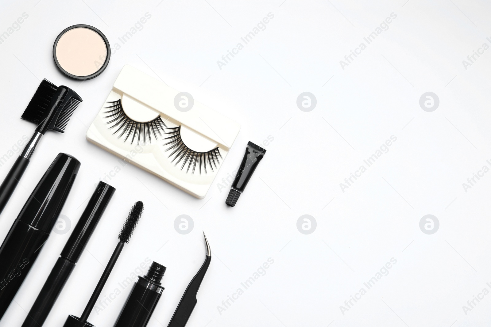 Photo of Composition with false eyelashes and other makeup products on white background, top view