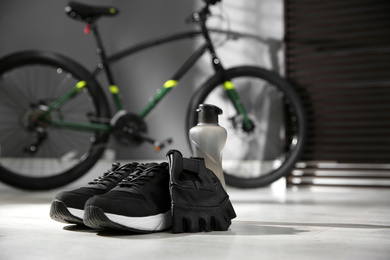 Photo of Bicycle gloves, shoes and bottle on floor 