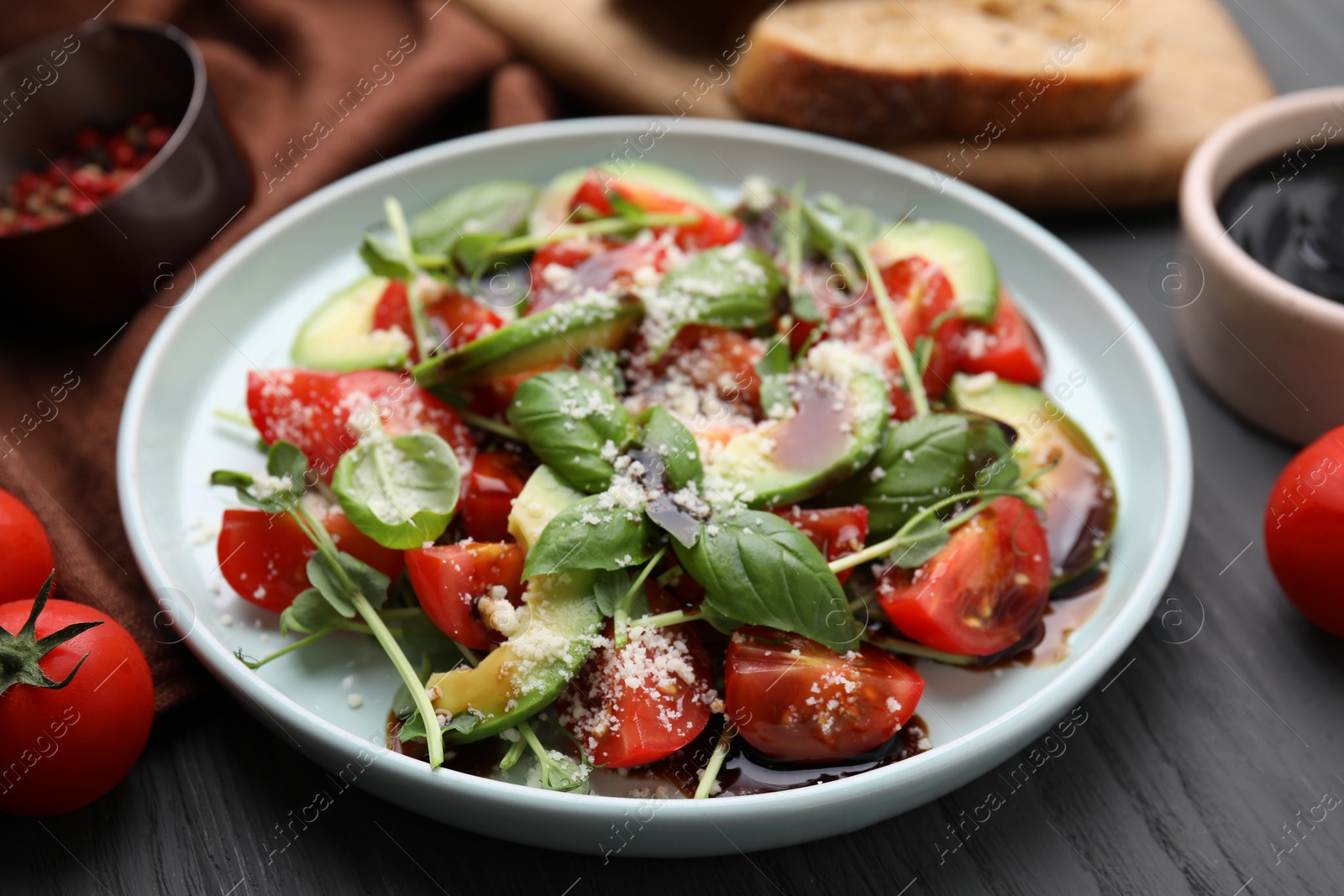 Photo of Tasty salad with balsamic vinegar on grey wooden table, closeup