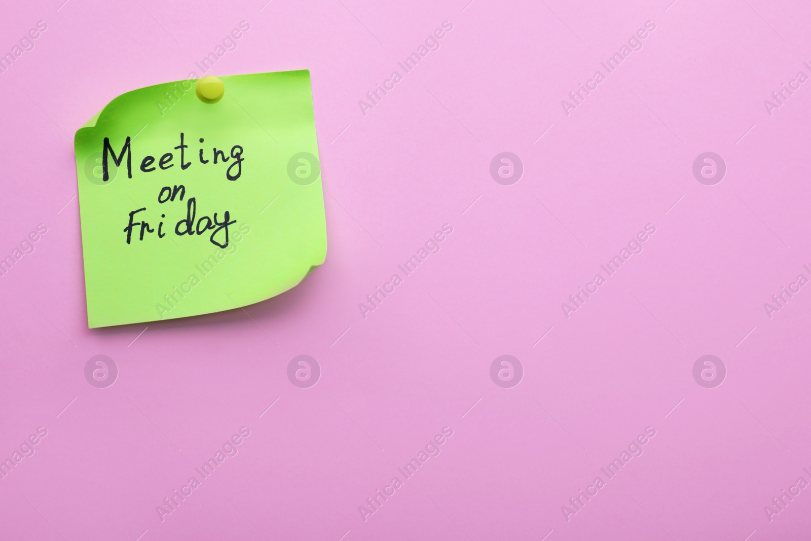 Photo of Paper note with words Meeting on Friday pinned to pink background, space for text