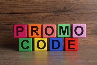 Words Promo Code made of colorful cubes with letters on wooden table