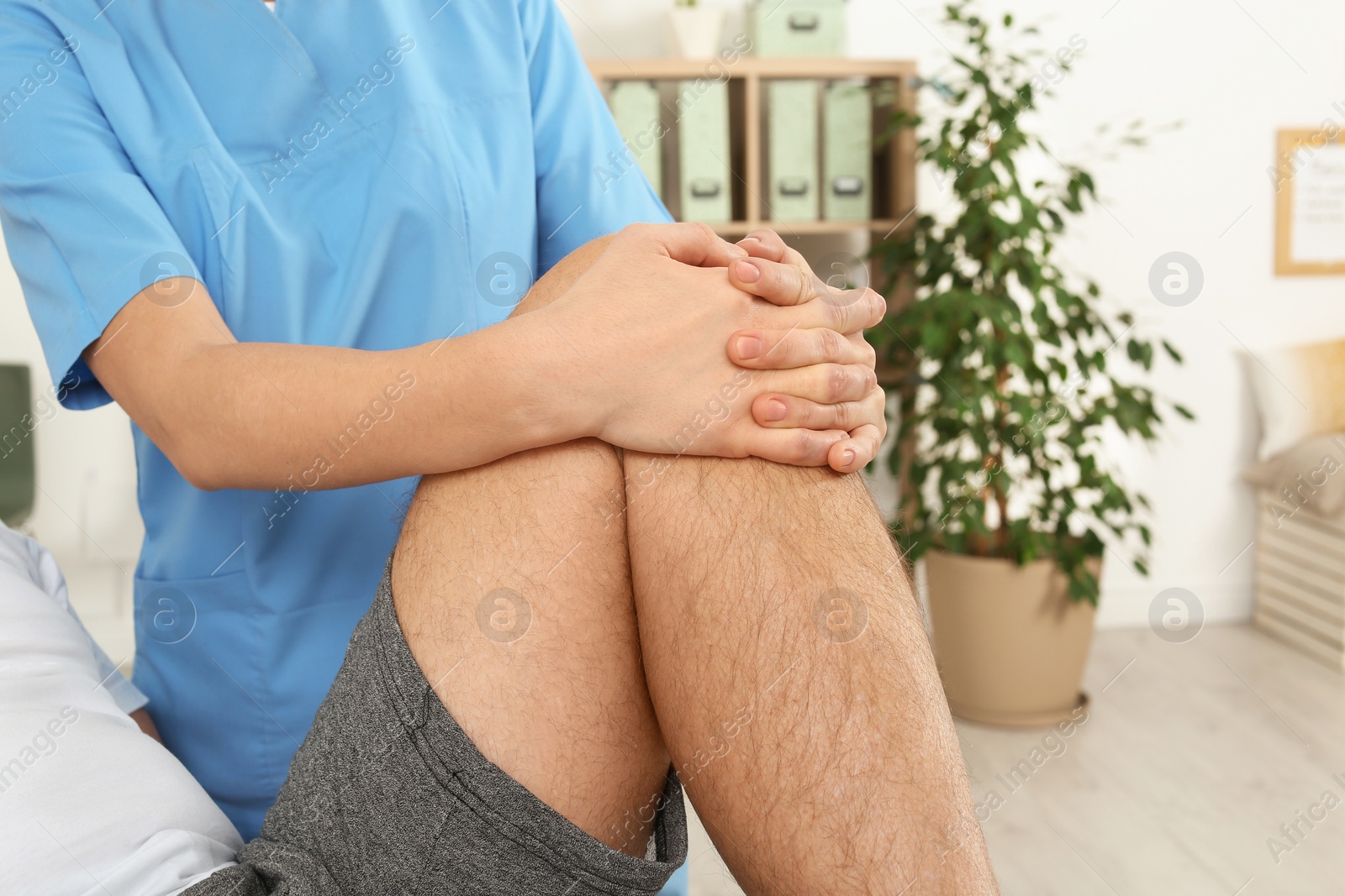 Photo of Physiotherapist working with patient in clinic, closeup. Rehabilitation therapy