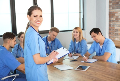 Medical student with groupmates in university library