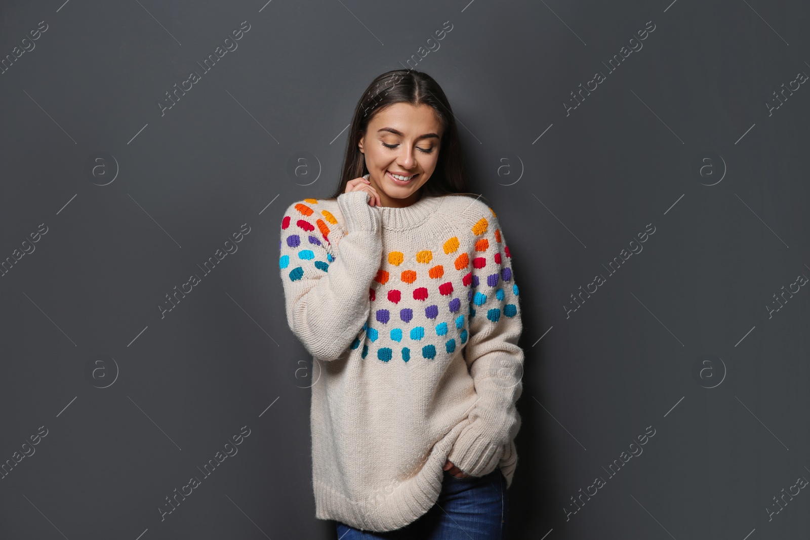 Photo of Beautiful young woman in warm sweater on dark background