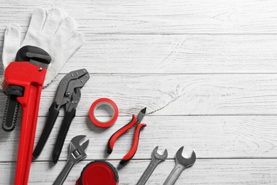 Photo of Flat lay composition with plumber's tools and space for text on wooden background