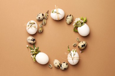 Photo of Frame made of eggs and natural decor on brown background, top view with space for text. Happy Easter