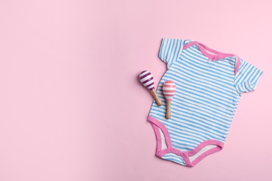 Photo of Flat lay composition with bodysuit and space for text on color background. Baby accessories