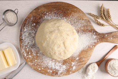 Fresh dough sprinkled with flour and other ingredients on white wooden table, flat lay