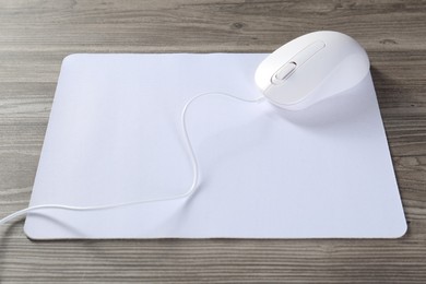 Wired mouse and mousepad on wooden table