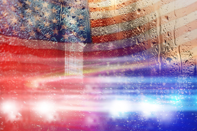 Image of Double exposure of American flag and police cars on street at night