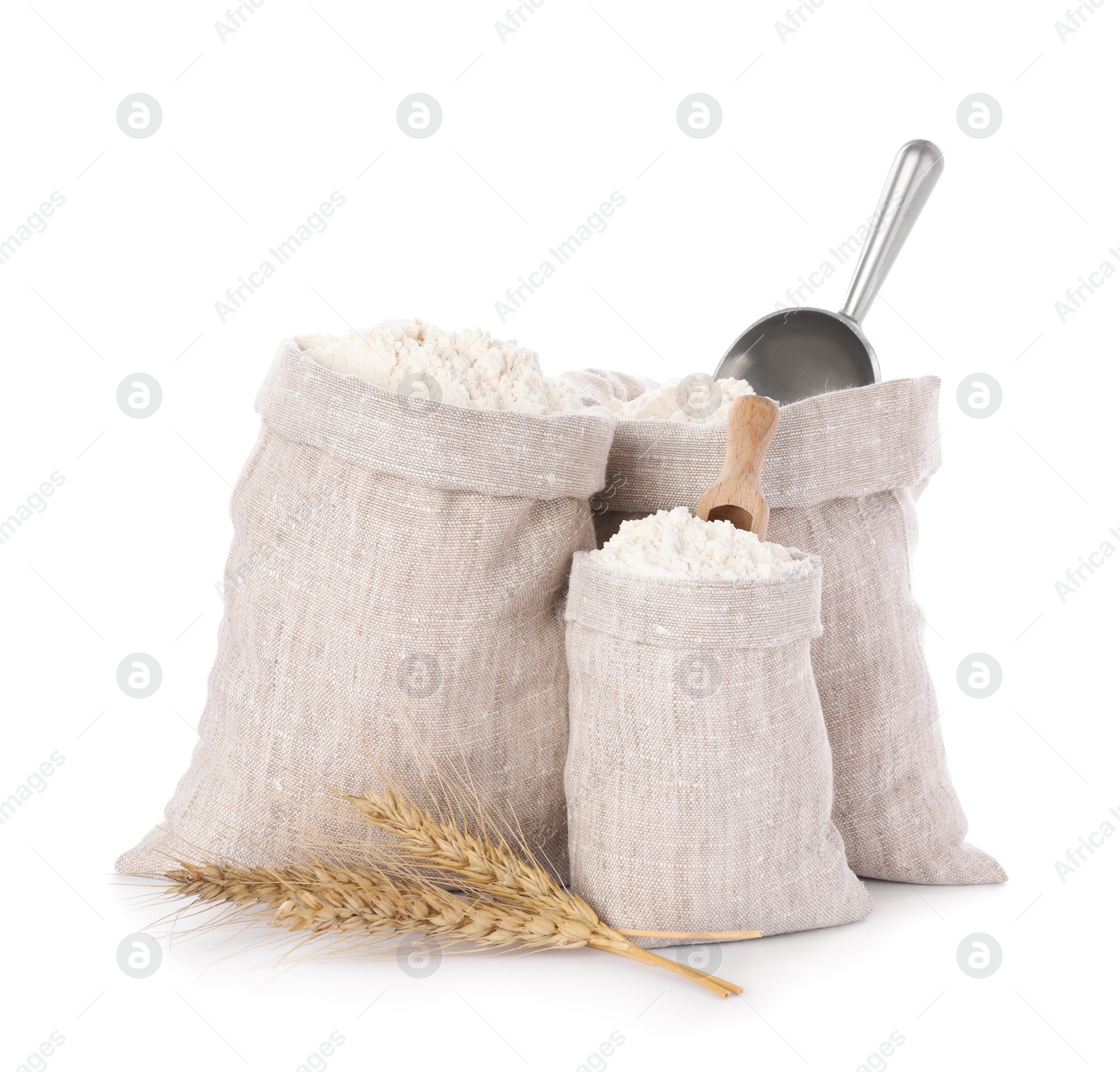 Photo of Sacks with flour and wheat spikes on white background