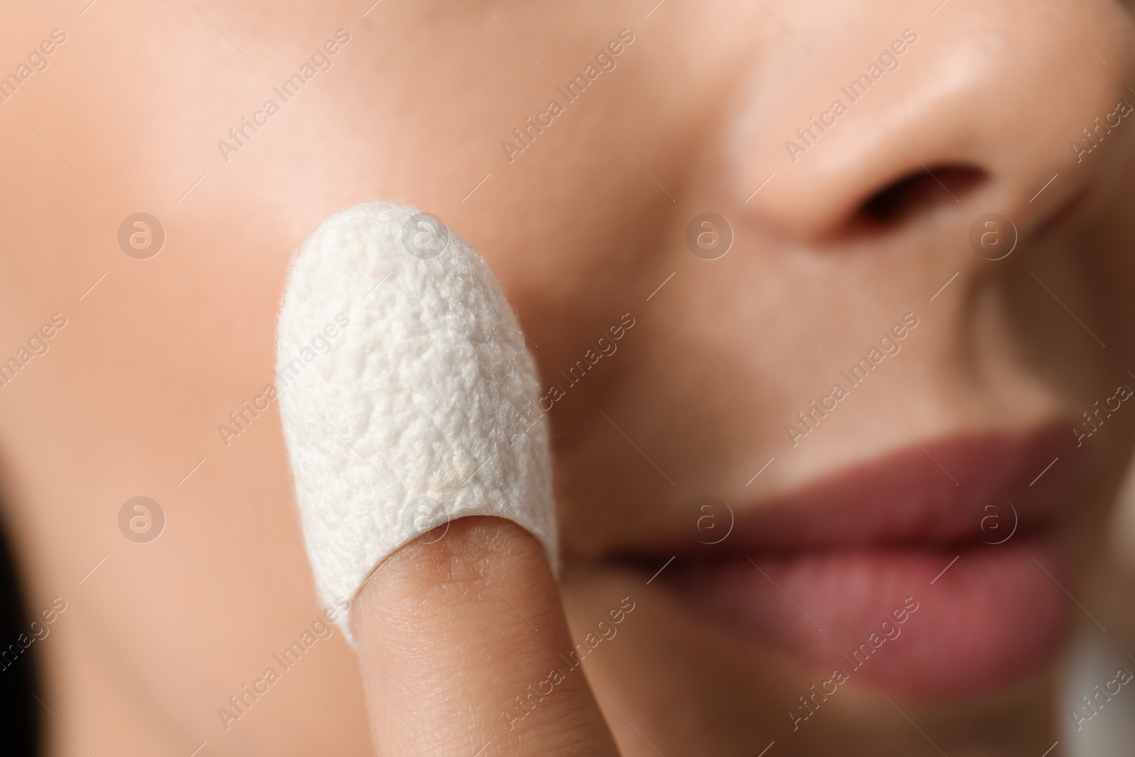 Photo of Woman using silkworm cocoon in skin care routine, closeup