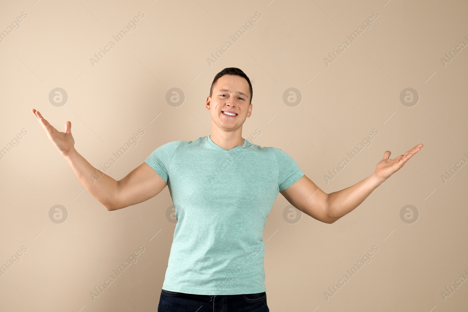 Photo of Confident handsome young man on beige background