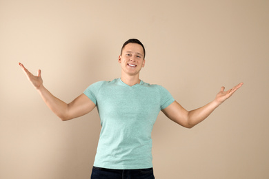 Confident handsome young man on beige background