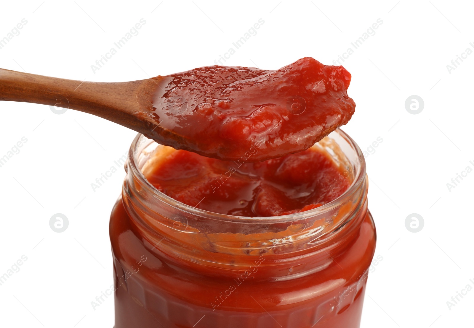 Photo of Spoon of delicious lecho over glass jar on white background, closeup