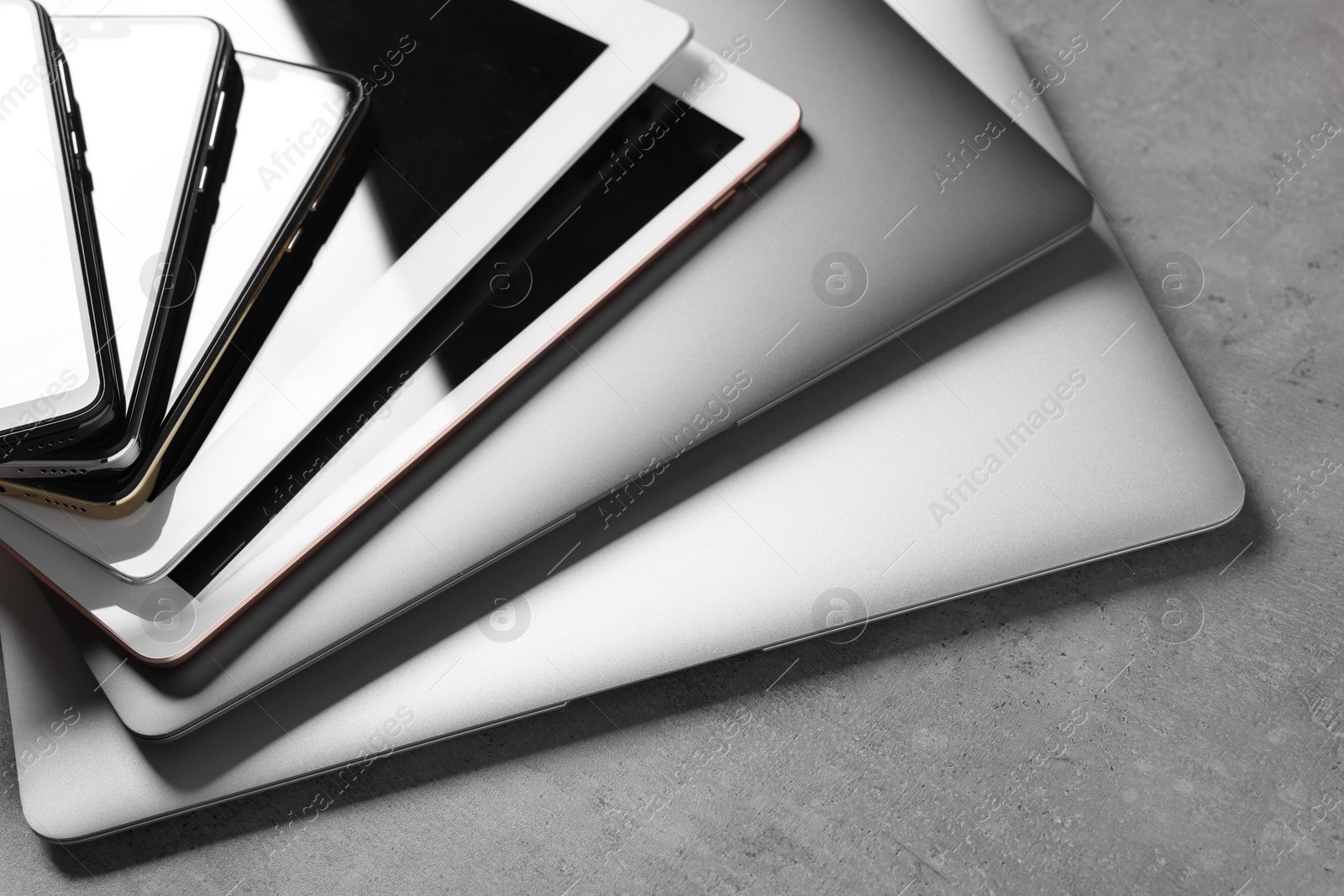 Photo of Many different modern gadgets on grey table, closeup