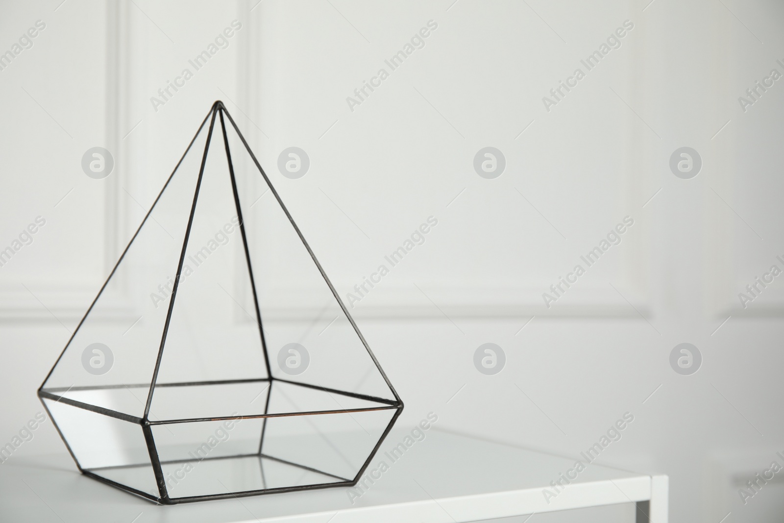 Photo of Empty glass florarium vase on white table indoors, space for text