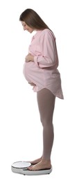 Pregnant woman standing on scales against white background