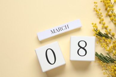 International Women's day - 8th of March. Wooden block calendar and beautiful flowers on beige background, flat lay