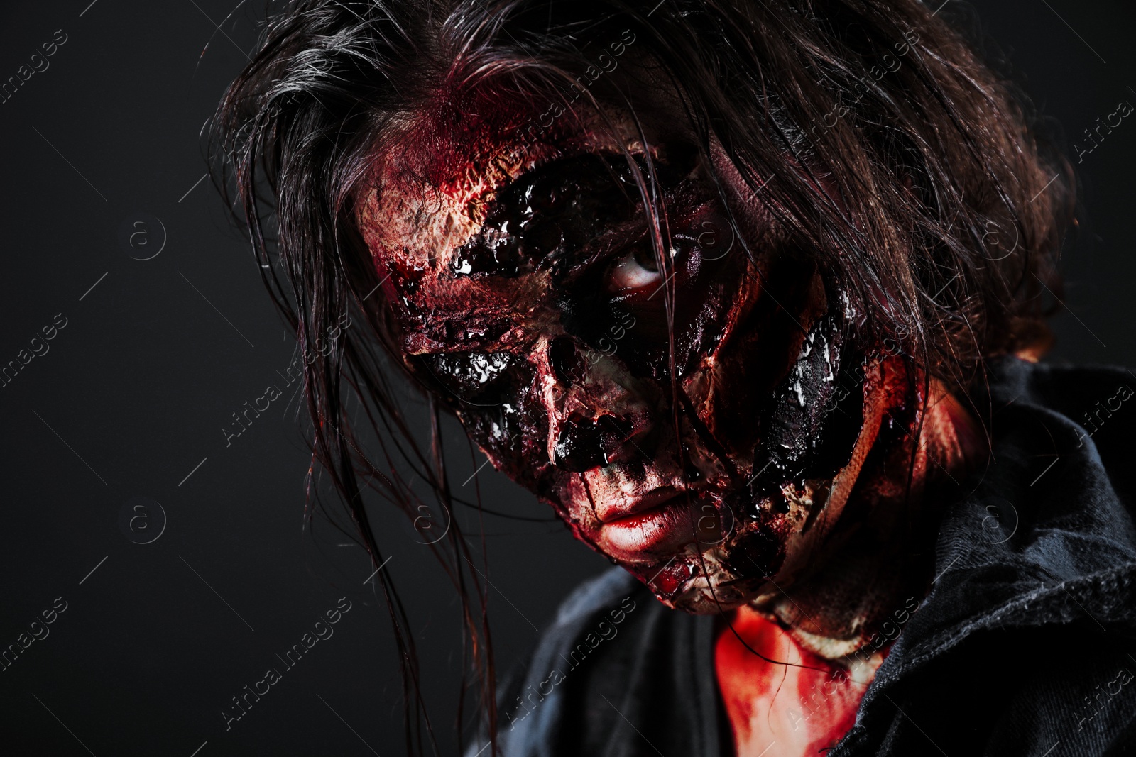 Photo of Scary zombie on dark background, closeup. Halloween monster