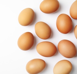 Photo of Raw chicken eggs on white background, top view