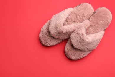 Photo of Pair of stylish soft slippers on red background, flat lay. Space for text