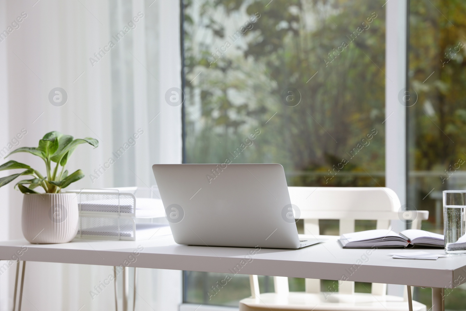 Photo of Comfortable workplace with modern laptop in office