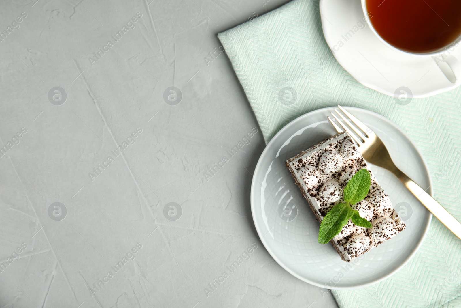 Photo of Flat lay composition with tiramisu cake and cup on table, space for text