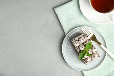 Flat lay composition with tiramisu cake and cup on table, space for text