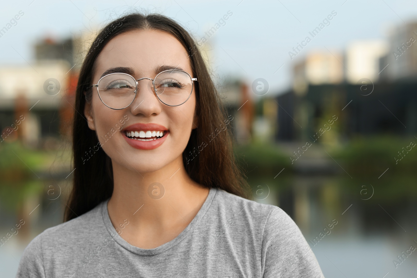 Photo of Portrait of beautiful woman in glasses outdoors. Attractive lady smiling and posing for camera. Space for text