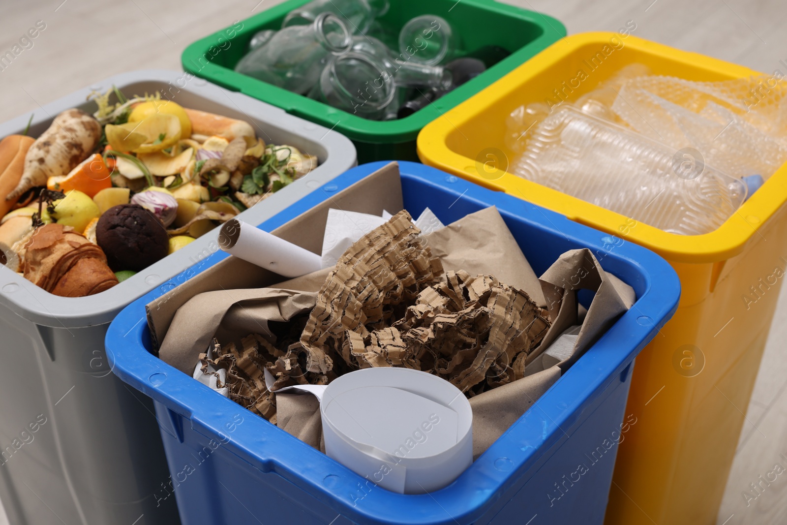 Photo of Garbage sorting. Full trash bins for separate waste collection indoors, closeup
